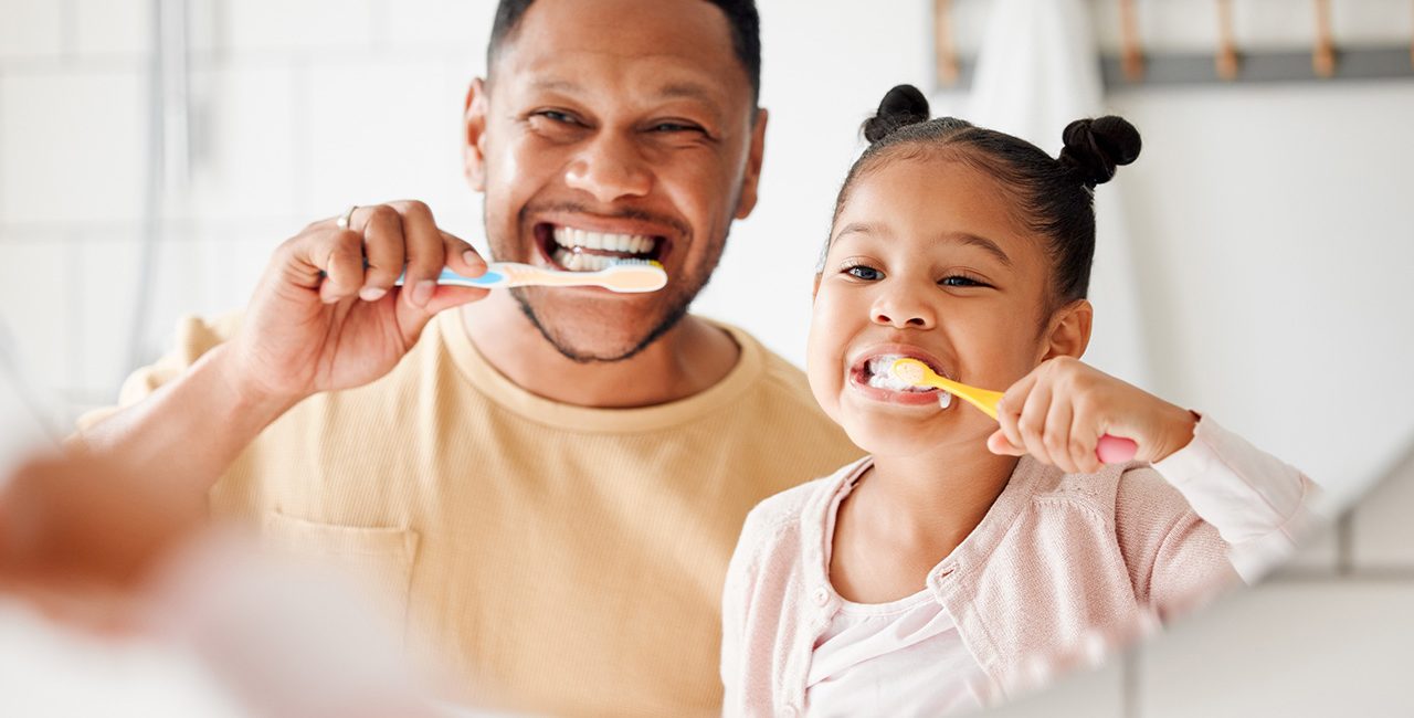 Man and child brushing teeth
